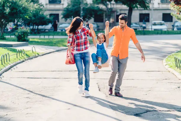 Photo of Young family with kid having fun in the park