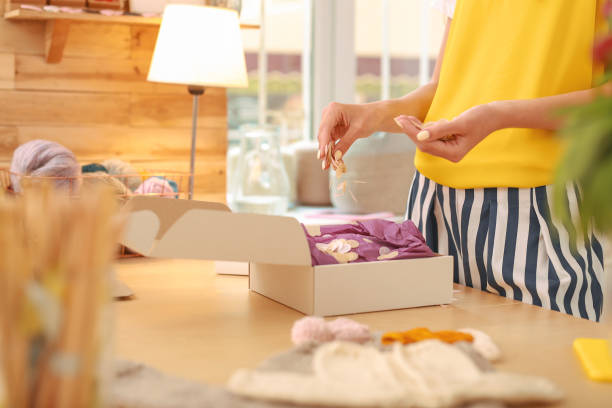 istock Needlewoman in yellow shirt decorating her package 980710664