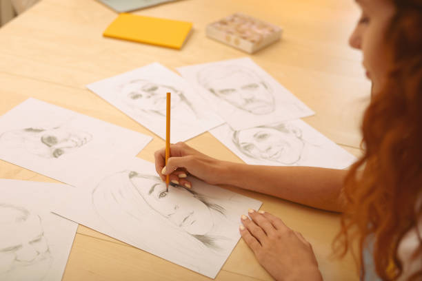 istock Red-haired creative person drawing caricatures 980714514