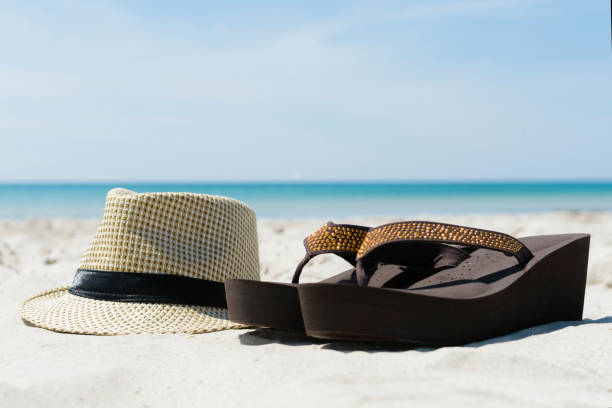 istock Vacation concept. Essentials on the sea beach. hat, flip-flops. copy-space 980721080