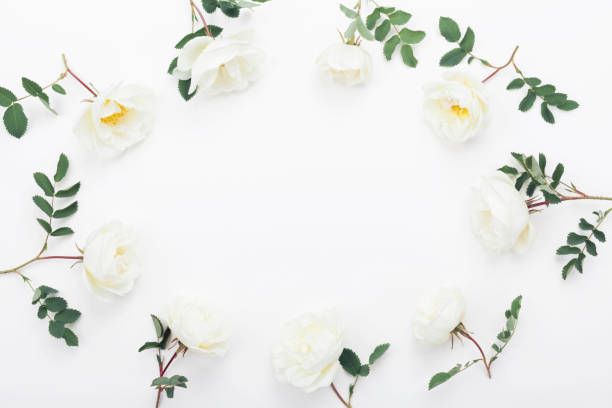 istock Frame of rose flowers and green leaves on white table top view. Beautiful wedding pattern. Flat lay. 980725168