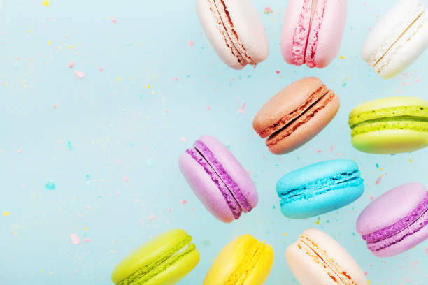 istock Flying cake macaron or macaroon on blue pastel background. Colorful almond cookies. 980728310