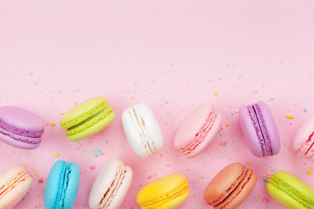 istock Macaron or macaroon on pink pastel background top view. Flat lay. 980728530