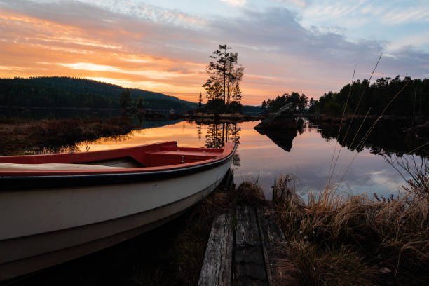 istock Boat near calm lake in sunset. 980728596