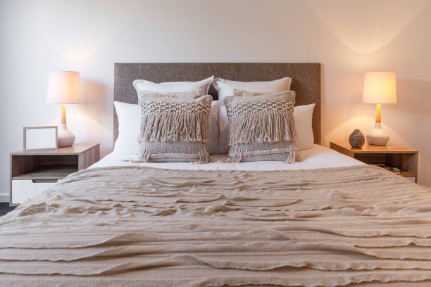 istock Decorative pillows on bed arrangement with bedroom lamps and bedside tables 980748636