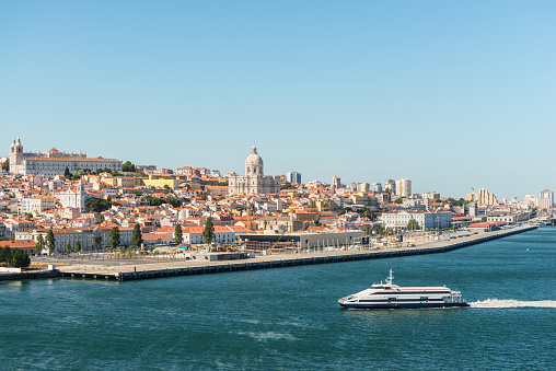 Lisbon cityscape, view of the old town Alfama, Portugal and passenger boat in the Tagus River