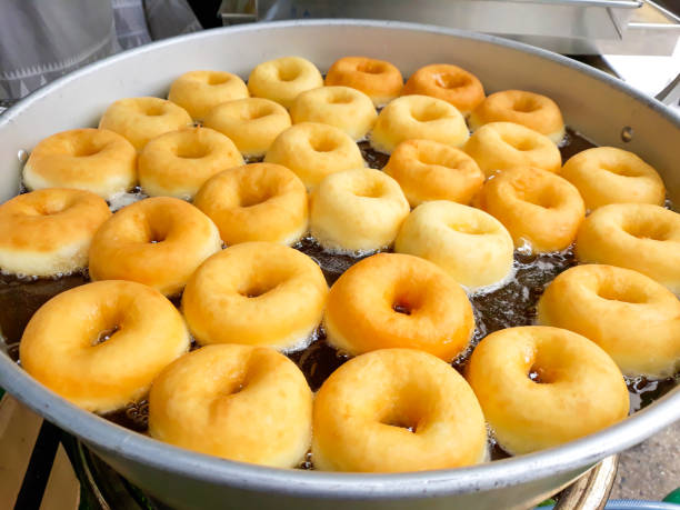 istock Donuts fried in hot oil in pan. 980771458
