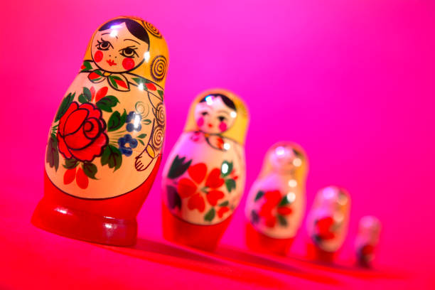 ROW OF PAINTED RUSSIAN DOLLS ON PINK BACKGROUD