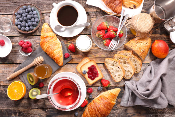 istock breakfast with coffee, tea, croissant and fruit 980775712