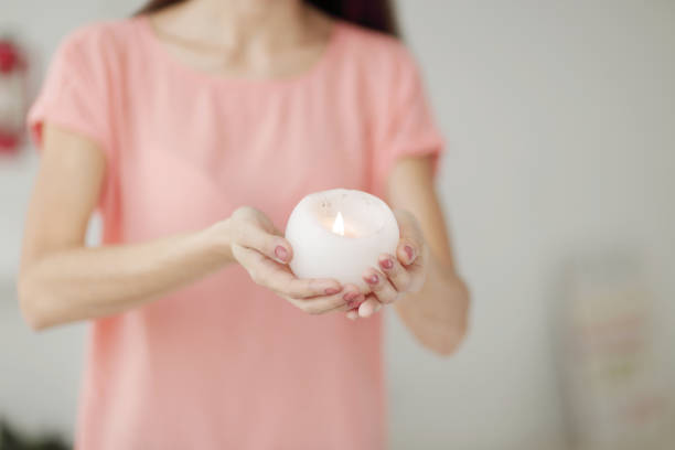 istock close up.a beautiful young woman extends a burning candle 980780602