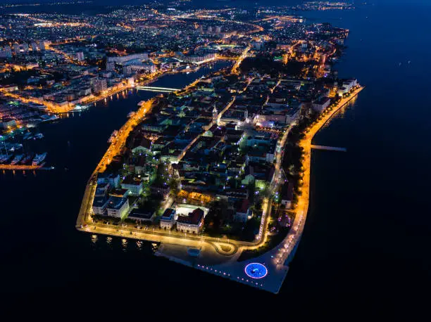 Old fortified peninsula in Zadar town with beautiful street lights and Adriatic sea (Jadransko more), photograph taken with drone