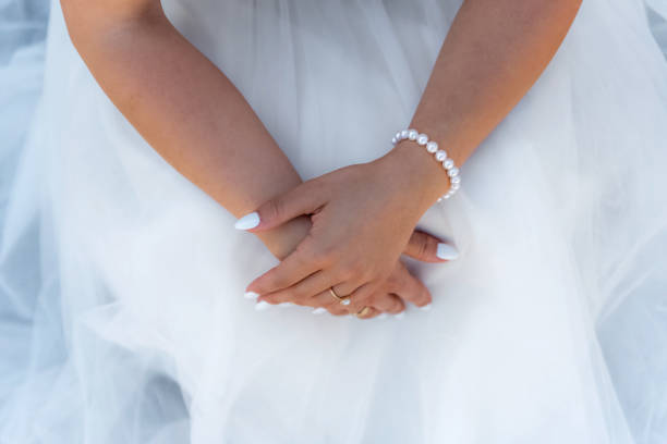 istock Bride hands on wedding dress 980787728