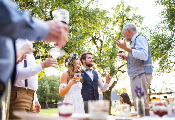 um homem sênior fazendo discurso na recepção do casamento fora no fundo. - wedding couple toast glasses - fotografias e filmes do acervo