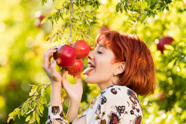 Girl in a neglected almond orchard. Girl in red walking in old almond garden