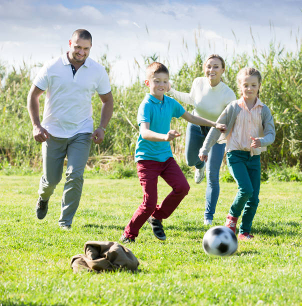 istock Cheerful parents with two kids playing soccer 980803424