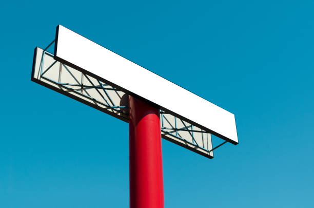 istock Blank billboard on a pole against the blue sky. 980807784