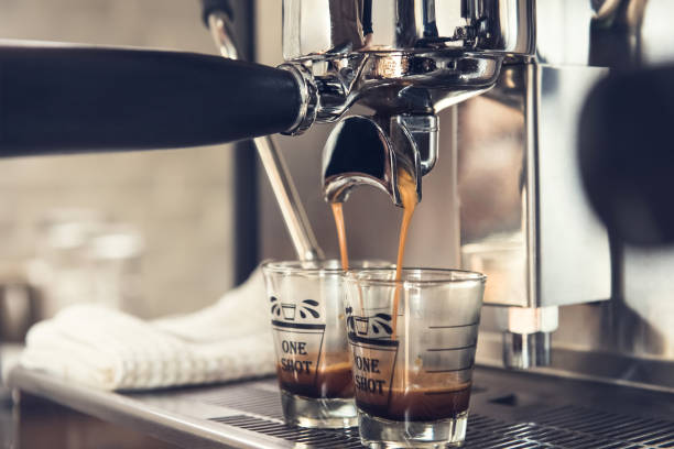 istock Coffee being brewed by the machine  into espresso shot glasses 980809120