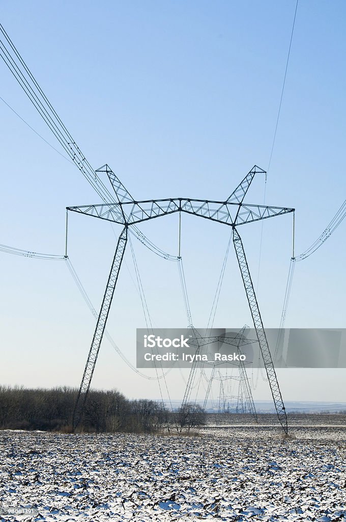 Line of electric pylons on winter field  Agricultural Field Stock Photo