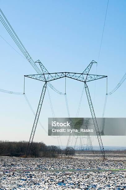 Line Of Electric Pylons On Winter Field Stock Photo - Download Image Now - Agricultural Field, Blue, Cable