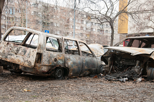 Totalmente destruidas y cerca de coches dañados, quemados en fuego en la zona de guerra o en manifestaciones civiles photo