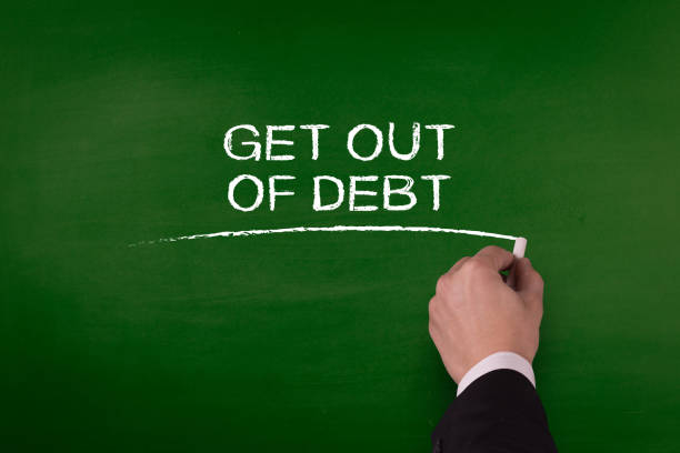 istock GET OUT OF DEBT word written by hand on blackboard 980844698