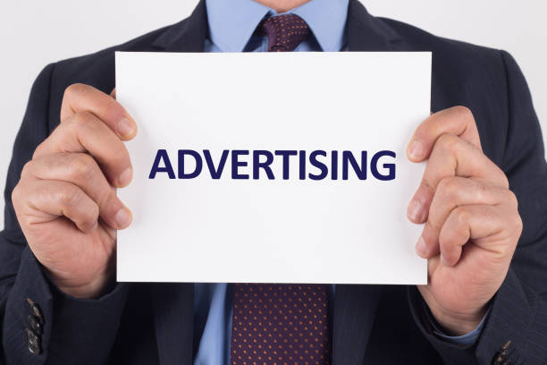 istock Man showing paper with ADVERTISING text 980847364