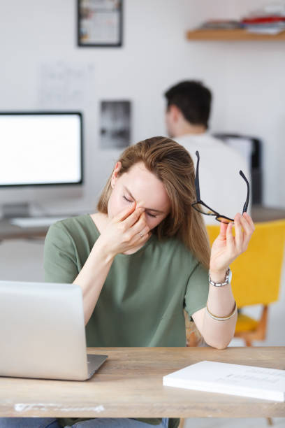 istock Overworked professional young male worker has headache after hard working day, holding eyeglasses, rubbing his eyes and massaging nose bridge over white studio background. Overwork concept 980851702