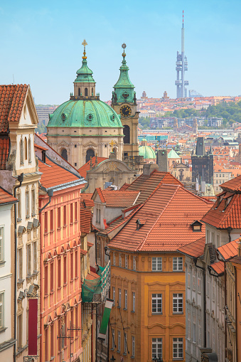 A view of the Mala Strana district in Prague, Czech Republic. The church towers belong to St Nicholas Church founded in the 18th century. In the far distance is the Zizkov Television Tower completed in 1992.