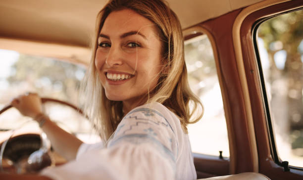 istock Beautiful female driving a old car 980857264