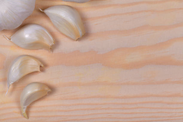 istock Several cloves of garlic on wood 980857666
