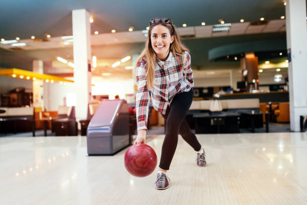 フォーカスハッピーを楽しむ女性ボーリング - bowling holding bowling ball hobbies ストックフォトと画像