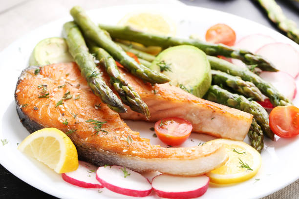 istock Steak of salmon with asparagus and vegetables 980871104