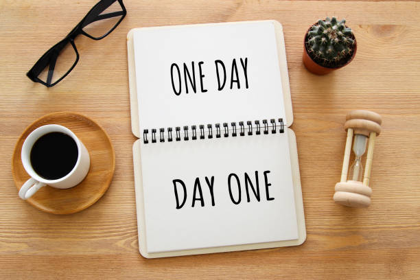 istock top view image of table with open notebook and the text one day turning into day one. success and personal development concept. 980880146