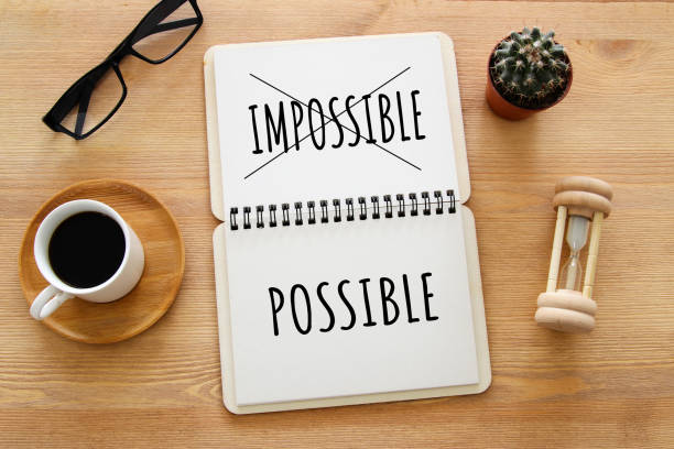 istock top view image of open notebook with the text impossible, cutting the word im so it written possible. success and challenge concept. retro style image. 980880156