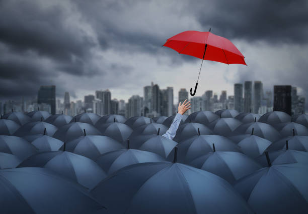 istock businessman with red umbrella among others, unique different concept 980881096