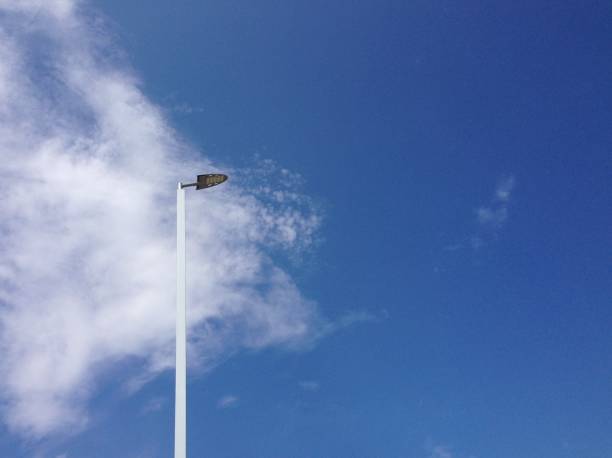 istock the white metal electric post and blue sky with white clouds at noon 980907938