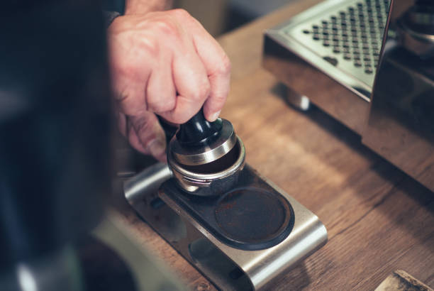 istock Espresso pouring from classic coffee machine into small white cup 980908386