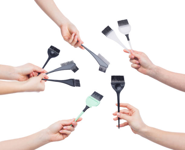 istock Hands holding brushes for hair dying isolated on white 980923640
