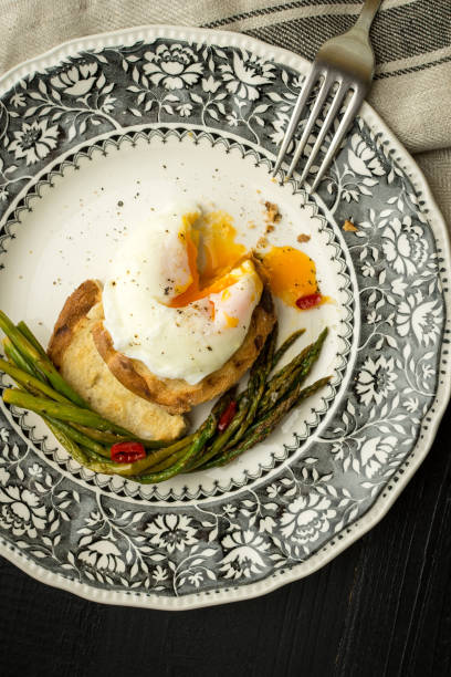 istock Freshly Poached Egg on Toast With Boiled Green Asparagus and Chili Peppers 980927086