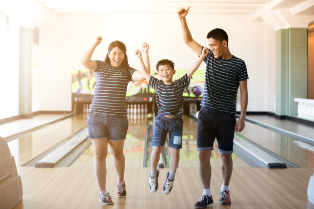 Family having fun at bowling club after skittles bowling ball ,blurry and soft focus Family having fun at bowling club after skittles bowling ball ,blurry and soft focus cricket bowler stock pictures, royalty-free photos & images