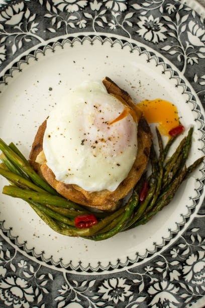 istock Freshly Poached Egg on Toast With Boiled Green Asparagus and Chili Peppers 980930576
