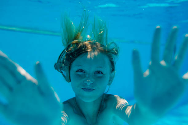 istock Young girl is diving in a pool 980930646