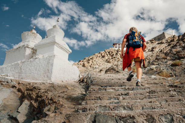 Tourist man climbs up stairs to tibetan holy place in Himalaya mountain Tourist man climbs up stairs to tibetan holy place in Himalaya mountain ladakh region stock pictures, royalty-free photos & images