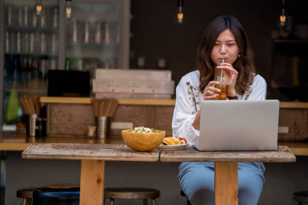 istock Young woman working on her laptop in a cafe 980937802