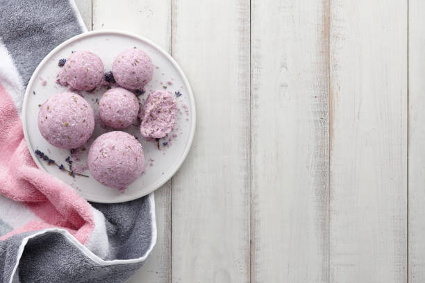 istock Handmade lavender bath bombs with towel on white planks 980940726