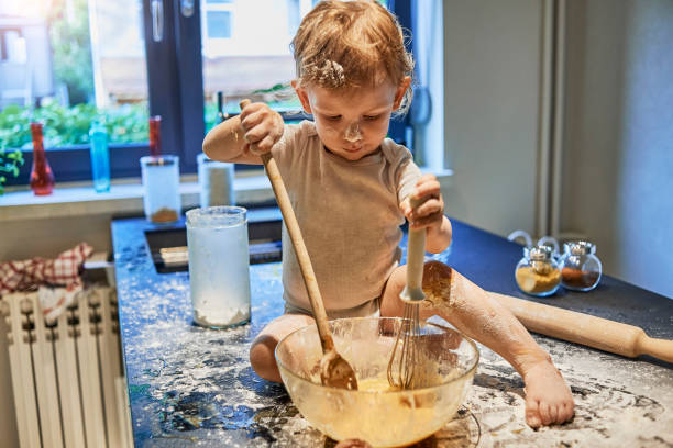 baby having fun making a mess in the kitchen stock photo