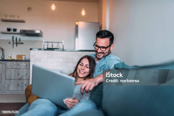 Relaxing At Home Watching Photos On Laptop Stock Photo - Download Image Now - Couple - Relationship, Laptop, Domestic Life