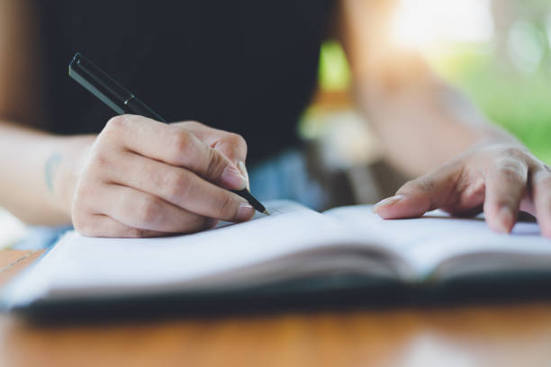 istock Checklist Writing Notice Remember Planning Concept,home office desk background,hand holding pen and writing note on wood table. 980952438