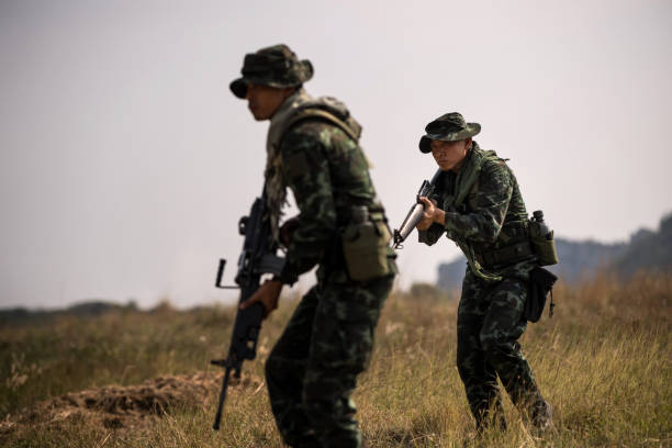 istock Squad of soldiers patrolling across the deep forest area. 980953442