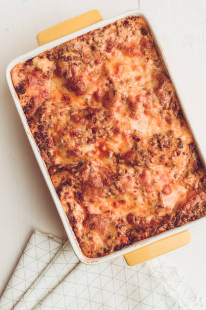 istock Lasagna Bolognese with Beef, Tomato Sauce and Green Basil on Rustic White Wooden Table 980968076